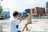 Mann fotografiert Frau an den Magellan-Terrassen, HafenCity, Hamburg, Deutschland