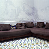 Couch in corner of room with tiled floor