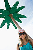 Female teenager under a palm-shaped shower at beach of Coney Island, Brooklyn, New York City, New York, USA