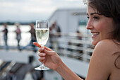 Frau mit Sektglas an Bord von Kreuzfahrtschiff MS Astor (Transocean Kreuzfahrten), Kiel, Schleswig-Holstein, Deutschland, Europa, MR