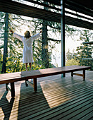 Frau streckt sich auf einer Terrasse, Vigilius Mountain Resort, Vigiljoch, Lana, Trentino-Südtirol, Italien