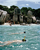 Menschen schnorcheln über Korallen vor der winzigen Insel Coco Island, La Digue and Inner Islands, Republik Seychellen, Indischer Ozean