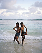 Two boys on the beach of Baie Lazare, south western Mahe, Republic of Seychelles, Indian Ocean