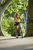 Frau fährt E-Bike, Radtour, Mittlerer Schlossgarten, Stuttgart, Baden-Württemberg, Deutschland