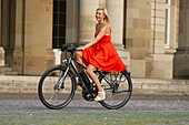 Woman cycling on an e-bike, bike tour, Schlossplatz, New Castle, Stuttgart, Baden-Wurttemberg, Germany