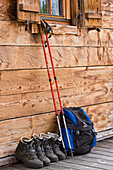 Hiking boots, rucksack and hiking poles n front of cabin