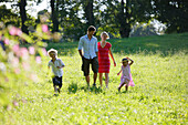 Family walking over meadow, Lake Starnberg, Bavaria, Germany