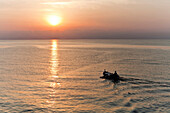 Fisherman boat at sunrise heading into the Tyrrhenian Sea off Bastia, Corsica, France