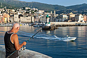 Angler steht auf der Mole, Bastia, Korsika, Frankreich