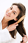 Portrait of a young woman brushing her hair