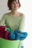 Young woman holding clothes basket