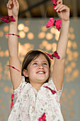 Smiling little girl playing with butterfly garland
