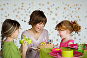 Woman and 2 little girls with birthday cake
