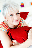 Senior woman holding a pillow tightly to her