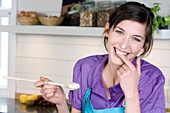 Portrait of a smiling woman tasting food