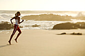 Young woman running on the beach