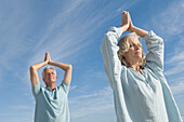 Couple in yoga attitude on the beach, outdoors