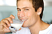 Portrait of a young man drnking glass of milk