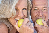 Portrait of smiling couple eating apples