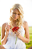 Young woman holding a red gerbera
