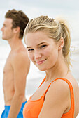 Portrait of a woman standing with a man on the beach