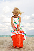 Girl holding a sand pail on the beach