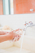 Woman washing hands in the bathroom