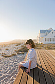 Girl sitting on a boardwalk