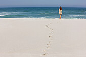 Rear view of a woman standing on the beach