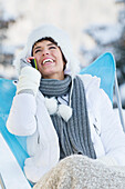 Young woman using mobile phone in snow