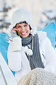 Young woman using mobile phone in snow