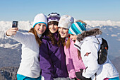 Four teenage girls in ski clothes, taking self portrait