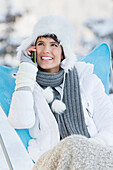 Young woman using mobile phone in snow