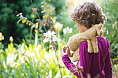 Rear view of a little boy walking in a garden