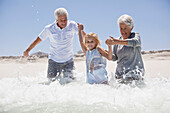 Girl enjoying on the beach with her grandparents