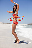 Woman playing with plastic hoops on the beach