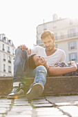 Woman lying on lap of a man at the ledge of a canal, Paris, Ile-de-France, France