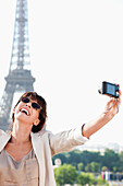 Woman taking a picture of herself with the Eiffel Tower in the background, Paris, Ile-de-France, France
