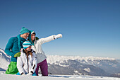 Couple and daughter in ski wear, looking away