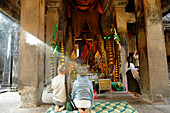 Elderly tourist couple at buddhist altar, Angkor Vat, Cambodia, Asia
