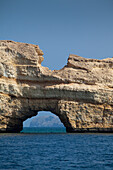 Ein Torbogen in einem Felsen, Bucht nahe des Oman Dive Centre, Muscat, Maskat, Oman
