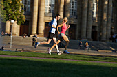 Young couple jogging, Upper Castle Gardena, Staatstheater, State Theater, Stuttgart, Baden Wurttemberg, Germany