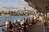People in fish restaurants on Galata bridge at Golden Horn, Istanbul, Turkey, Europe