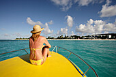 View of woman from behind on boat, Shoal Bay, Anguilla
