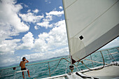 Boy sitting on gang plank on sail boat, Whitsunday Islands, Queensland, Australia