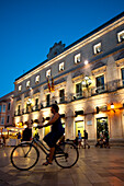 Cyclists In Placa De La Catedral In Ciutadella At Night, Menorca, Balearic Islands, Spain