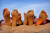 Sandy children's feet, Patnum Beach, Goa, India.