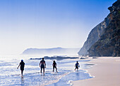 Family of four walking on beach, rear view, Garden Route, South Africa