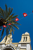 Cathedral of St Vincent de Paul, palm tree, and Tunisia flags, Tunis, Tunisia