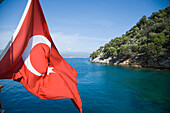 Turkish flag on boat by coast, Fethiye Bay, Turkey